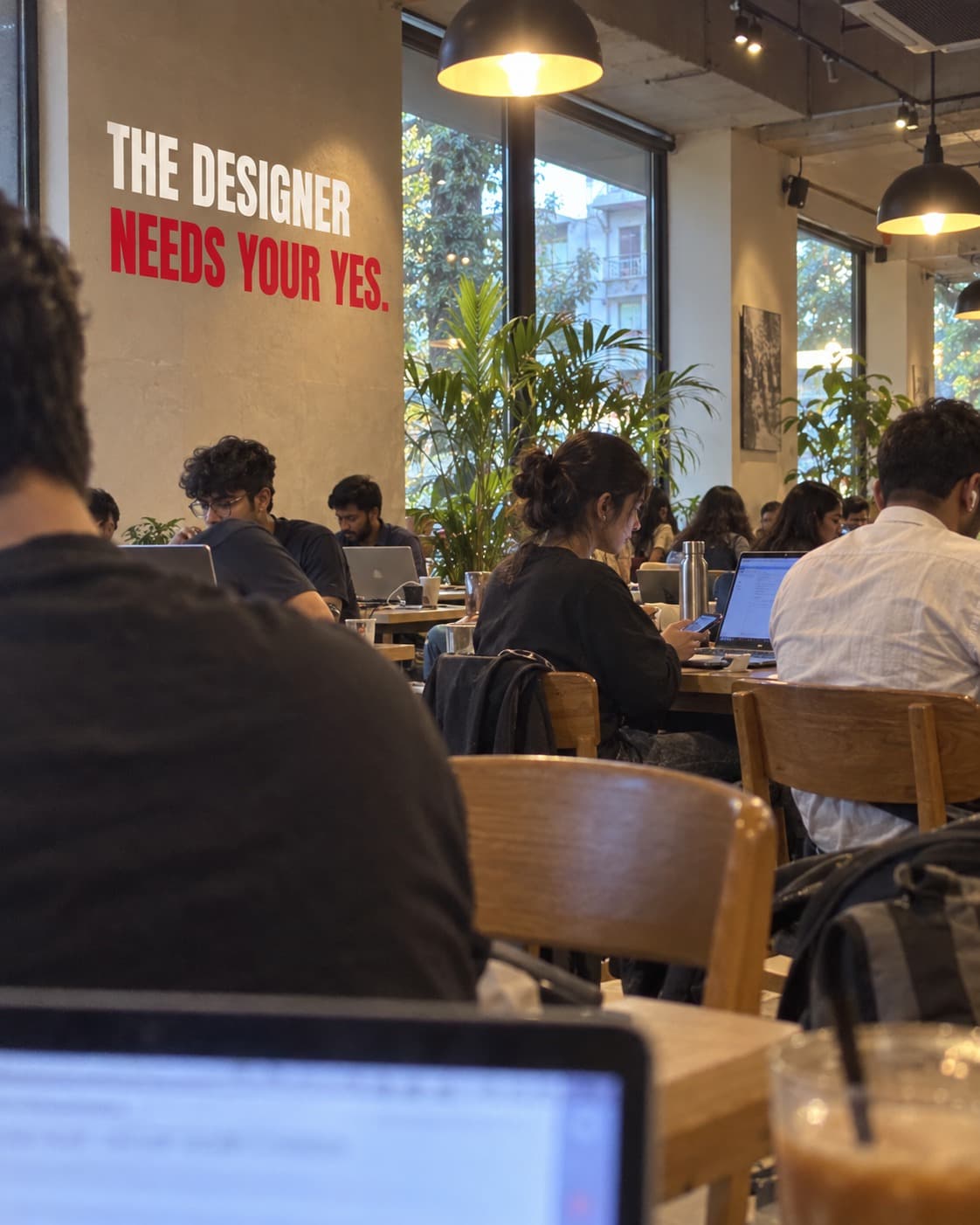 People working in a studio beneath the words: The designer needs your yes.