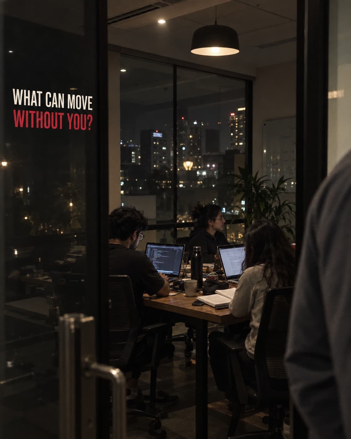 A team working in a glass meeting room beneath the question: What can move without you?